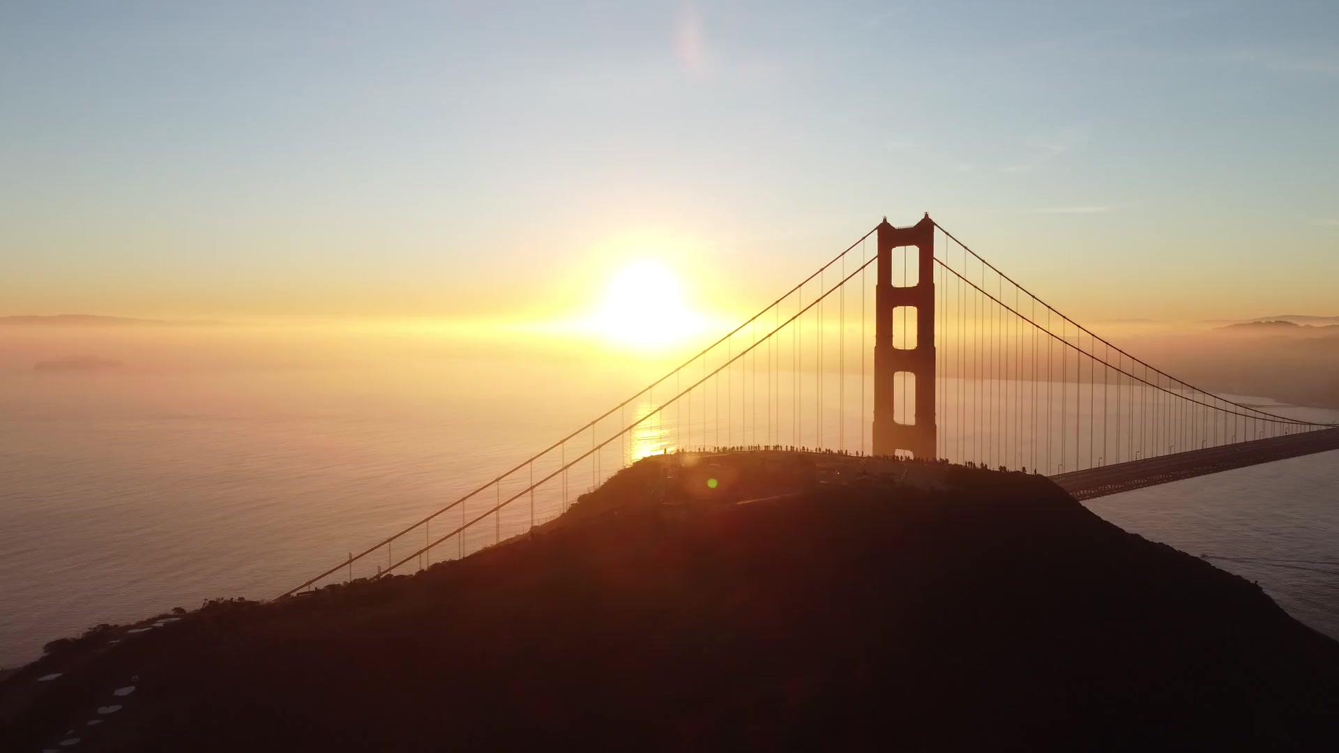 Aerial view of the Golden Gate Bridge silhouetted at sunrise
